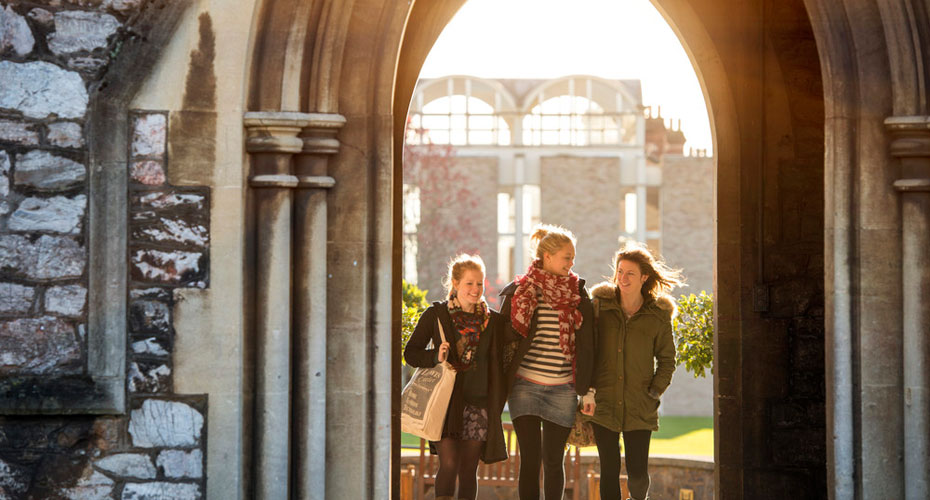 Group of students walking under archway at St Luke's campus