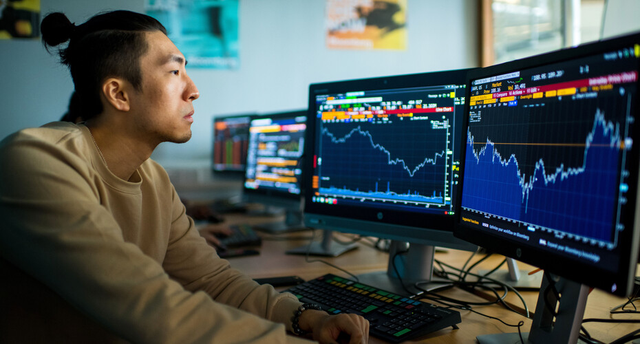 A student examining a financial graph in the computer lab