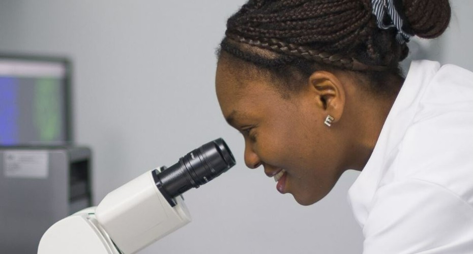 Researcher looking through a microscope