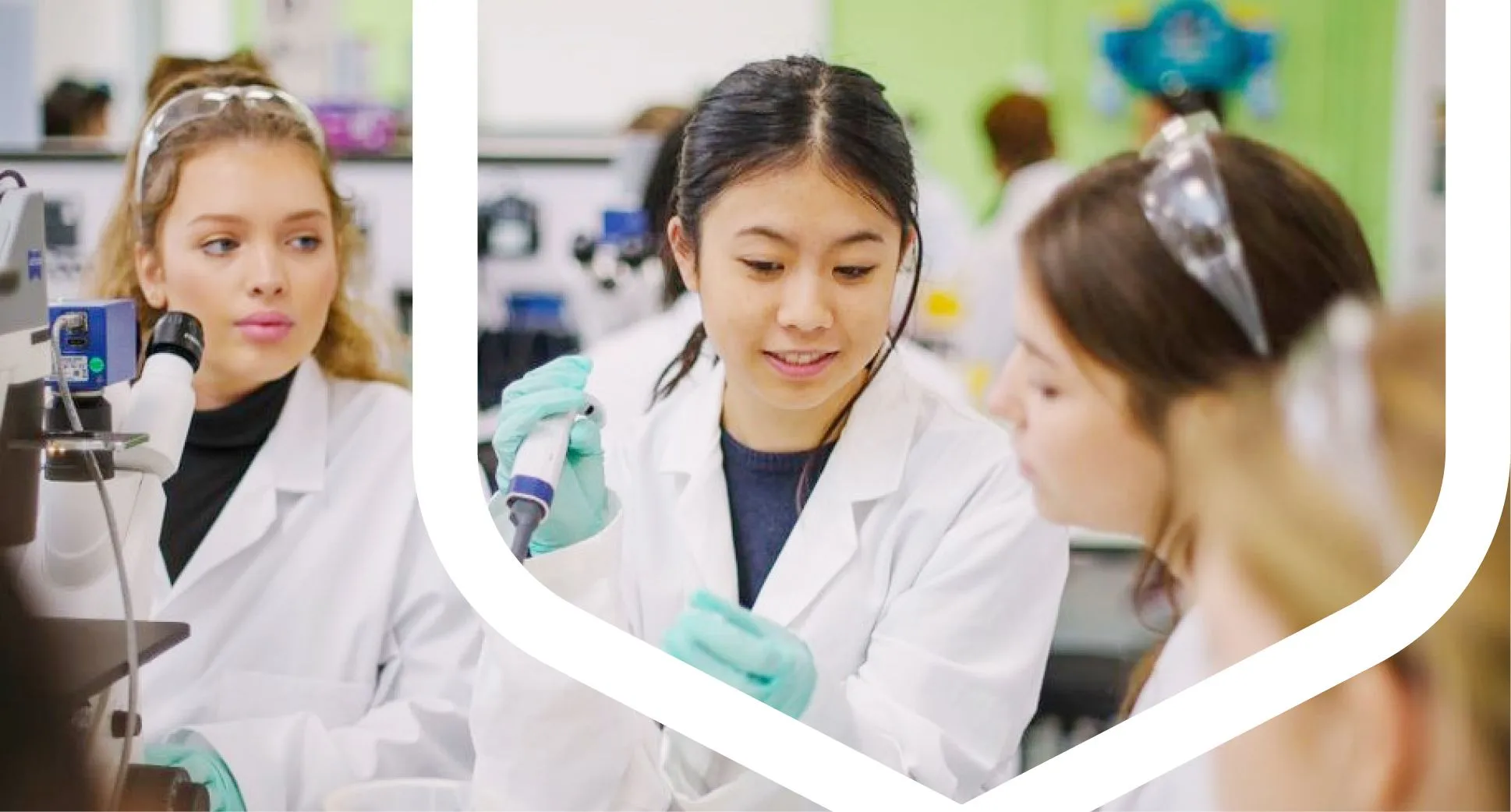 Several students in lab coats collaborating on a project in a laboratory environment.