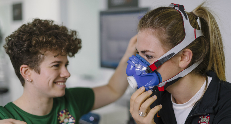A Sport Sciences student adjusts a fellow student's oxygen monitor for an experiment