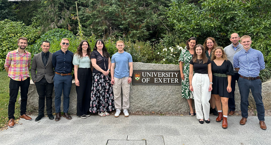 The Nutritional Physiology team standing in from the rock with the university logo on it.