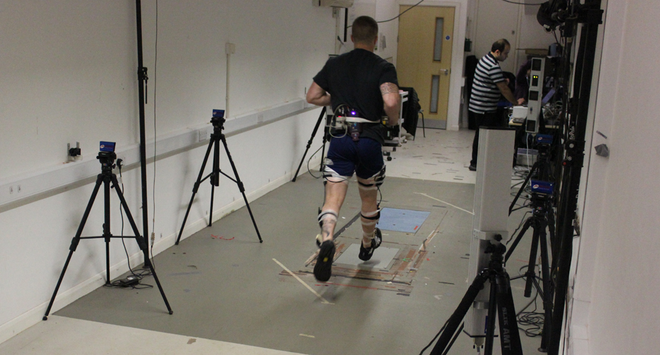 A Royal Marine running on a biomechanics machine, attached to various measuring devices