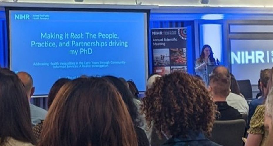 A person giving a presentation at a podium in front of an audience