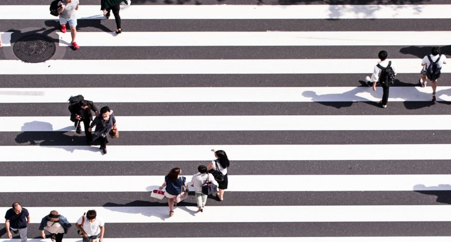 people walking across a pedestrian crossing